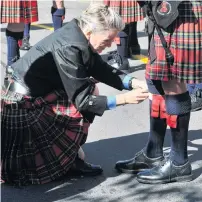  ??  ?? Spot on . . . Canterbury Caledonian Pipe Band drum major Wendy Chisholm, of Christchur­ch, checks the band’s uniforms are perfect before the pipe band march begins in the Octagon.