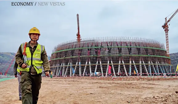  ??  ?? Workers constructi­ng a near-zero emissions power plant in Fuxian County, Yan’an City, Shaanxi Province.