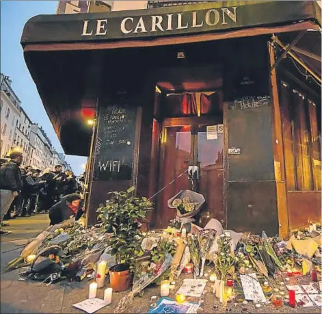  ??  ?? Flores y velas colocadas como homenaje a las víctimas de los atentados de París, ante Le Carillon