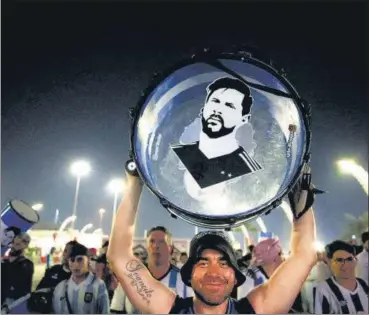  ?? REUTERS ?? An Argentina fan holds up his drum with an image of Lionel Messi on it on the Doha Corniche.