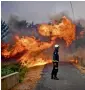  ?? AFP ?? A firefighte­r stands in the middle of a road near the village of Sanguinhei­ra in Macao, Portugal. —