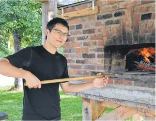  ?? KIRK STARRATT • SALTWIRE NETWORK ?? Front Street Community Oven operations and programmin­g co-ordinator Duncan Ebata prepares the fire for a recent evening booking.