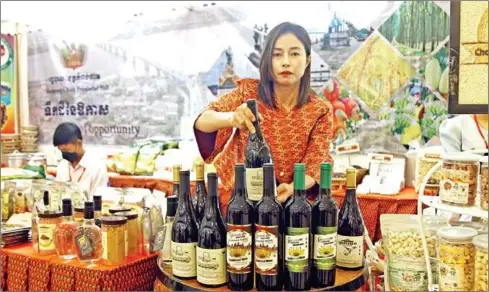  ?? HENG CHIVOAN ?? Yus Phally shows her wine made from banana at a recent expo.