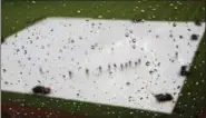  ?? DAVID GOLDMAN — ASSOCIATED PRESS ?? Raindrops sit on the window of the press box as grounds crew workers clear water from the infield tarp during a rain delay between the Braves and the Nationals in Atlanta on May 20, 2017.