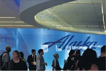  ?? Genaro Molina Los Angeles Times ?? PASSENGERS WAIT to check in at Alaska Airlines’ remodeled Terminal 6 at Los Angeles Internatio­nal Airport in 2012. The carrier is experiment­ing with a new do-it-yourself bag-tagging system at LAX.