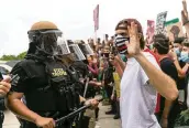  ?? MATIAS J. OCNER mocner@miamiheral­d.com ?? Protesters and Florida Highway Patrol officers meet on one of the ramps of the Julia Tuttle Causeway on June 5, 2020, during a Justice for George Floyd rally that began in Wynwood.