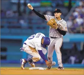  ?? Marcio Jose Sanchez Associated Press ?? THE GIANTS’ Wilmer Flores forces Mookie Betts at second base and completes a double play in the second. Betts scored the Dodgers’ first run in the first inning.