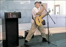  ?? Katherine Rohloff/Post-Gazette ?? Dan Schlegel, 67, of the North Side sings to his audience about the importance of life Monday at the Human Library talk at the Carnegie Library in East Liberty.