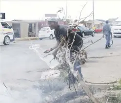  ??  ?? EMERGENCY MEASURE. Sebokeng resident Isaac Bobo Nkosi puts out a fire with a bucket of water at Zone 10 yesterday.
