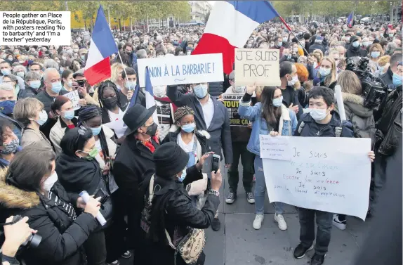  ??  ?? People gather on Place de la République, Paris, with posters reading ‘No to barbarity’ and ‘I’m a teacher’ yesterday