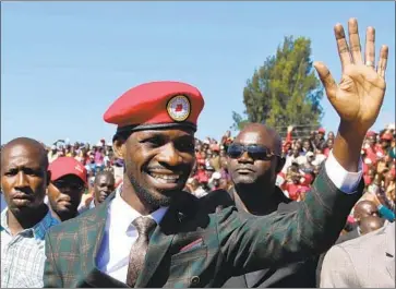  ?? Aaron Ufumeli EPA/Shuttersto­ck ?? BEFORE he became a politician, Bobi Wine, center, whose real name is Robert Kyagulanyi Ssentamu, was a well-known musician. His songs about growing up in a slum earned him the moniker “Ghetto President.”