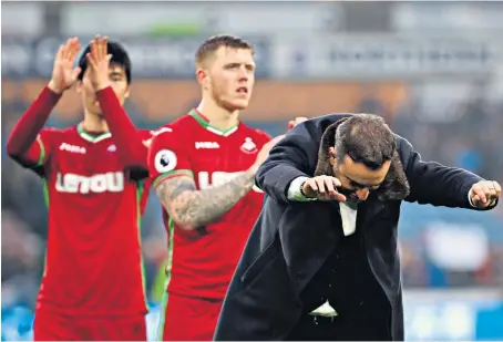  ??  ?? Mutual admiration: Swansea manager Carlos Carvalhal bows down to the fans at the end of his side’s battling draw at Huddersfie­ld