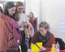  ?? FOTO: KALBRECHT ?? Autorin Katja Brandis gibt den interessie­rten Schülern am RNG in Wangen Autogramme.