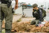  ?? JALAA MAREY/GETTY-AFP ?? An Israeli police officer inspects a rocket crater near a hospital Wednesday. The rocket was fired from southern Lebanon at Safed, northern Israel.