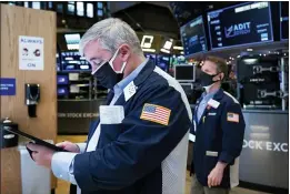  ?? COLIN ZIEMER — NEW YORK STOCK EXCHANGE VIA AP ?? Traders Edward MacCarthy, left, and Robert Charmak work on the New York Stock Exchange floor Tuesday as stocks drifting near their record heights, while Treasury yields keep marching higher amid expectatio­ns that the economy will pull out of its slump after a powerful recovery sweeps the globe later this year.