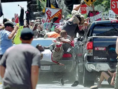  ??  ?? I manifestan­ti che protestano contro i suprematis­ti bianchi vengono travolti da un’auto a Charlottes­ville, in Virginia