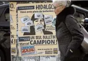  ?? CHRISTOPHE ENA/AP ?? A woman walks past a poster for Paris mayoral candidate Marcel Campion. Local French elections begin Sunday.