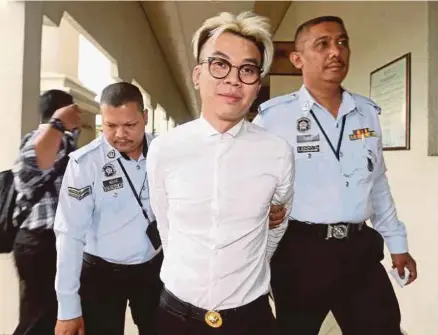  ?? PIC BY SALHANI IBRAHIM ?? Deejay Ooi Kok Wei, 31, being led out of the Kuala Lumpur court complex after he was charged with driving under the influence of alcohol yesterday.