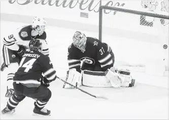  ?? TREVOR HAGAN THE CANADIAN PRESS ?? Edmonton Oilers’ Connor McDavid (97) scores on Jets goaltender Connor Hellebuyck with Josh Morrissey trailing during National Hockey League action in Winnipeg on Tuesday. The Oilers won, 5-4 in overtime.