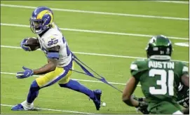  ?? Wally Skalij Los Angeles Times ?? RAMS RUNNING BACK Cam Akers carries the ball as a Jets defensive player tugs on his uniform. Akers f inished with 63 yards rushing in 15 attempts.