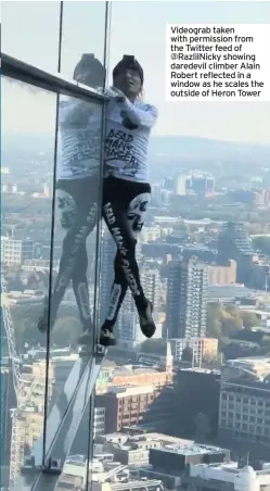  ??  ?? Videograb taken with permission from the Twitter feed of @Razlilnick­y showing daredevil climber Alain Robert reflected in a window as he scales the outside of Heron Tower