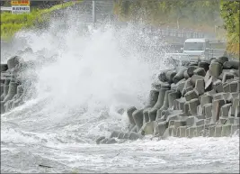  ?? The Associated Press ?? High waves pound the coast of Kagoshima, Japan, on Sunday. It was part of a typhoon that blew off rooftops and left homes without power.