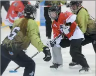  ?? NEWS PHOTO RYAN MCCRACKEN ?? Brooklyn Burzminski of the Medicine Hat Solis carries the ring through a pair of Medicine Hat Smash players during an exhibition ringette game at the Family Leisure Centre last Sunday.