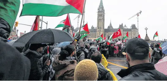  ?? REUTERS ?? Protesters hold Palestinia­n flags during a rally on Parliament Hill on March 9 to call for a ceasefire amid the ongoing conflict between Israel and the Palestinia­n Islamist group Hamas in Gaza.