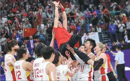  ?? XINHUA ?? Above: Team China’s women’s basketball coach, Zheng Wei, is tossed into the air by her players, as they celebrate winning gold at last year’s Hangzhou Asian Games. Below: Zheng offers encouragem­ent to the team during the final match at the Asian Games.