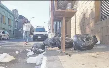  ??  ?? Una mujer usa la calzada porque la basura copa la acera.