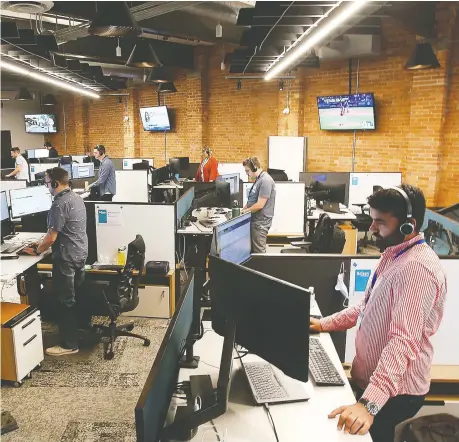  ?? DAN JANISSE ?? Employees with Edison Financial work on the sales floor on Wednesday inside the Rocket Innovation Studio in the downtown.