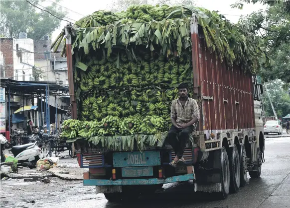  ??  ?? A truck for inter-state transport in Punjab, above. A Mahindra &amp; Mahindra car plant in Maharashtr­a, below. The rupee has fallen about 10 per cent against the dollar this year