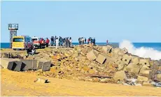  ??  ?? QUICK RESPONSE: Emergency personnel and bystanders were at the West Beach pier on Saturday after a man went missing in the surf, with two others emerging from the water uninjured