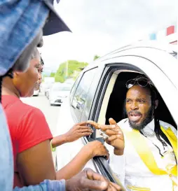  ?? GLADSTONE TAYLOR/MULTIMEDIA PHOTO EDITOR ?? Self-proclaimed emperor LA Lewis interactin­g with person on Olympic Way in St Andrew West Central in the vicinity of the Olympic Gardens Civic Centre on Monday.
