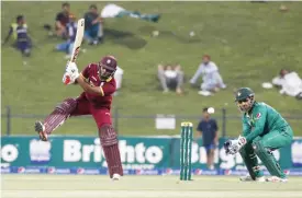  ??  ?? ABU DHABI: West Indies’ Evin Lewis (left) misses the ball as Pakistan’s wicketkeep­er Sarfraz Ahmed fields during the 3rd T20I cricket match between Pakistan and the West Indies at Sheikh Zayed Cricket Stadium yesterday. —AFP