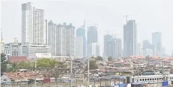  ??  ?? Photo shows high-rise buildings behind residentia­l houses in Central Jakarta. The four richest Indonesian­s are wealthier than the poorest 100 million people in the country, a study has found, highlighti­ng how huge numbers have been left behind as the...