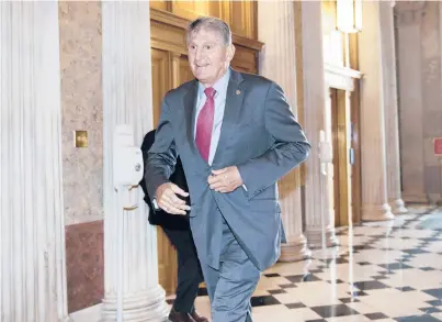  ?? J. SCOTT APPLEWHITE/AP ?? Sen. Joe Manchin, D-W.Va., rushes into the Senate last month ahead of an annoucemen­t by Mitch McConnell.