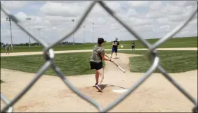  ?? CHARLIE NEIBERGALL ?? Visitors play on the field at the Field of Dreams movie site, Friday, June 5, 2020, in Dyersville, Iowa. Major League Baseball is building another field a few hundred yards down a corn-lined path from the famous movie site in eastern Iowa but unlike the original, it’s unclear whether teams will show up for a game this time as the league and its players struggle to agree on plans for a coronaviru­s-shortened season.