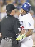  ??  ?? YASIEL PUIG is held by umpire Rob Drake after a high and inside pitch in the second inning.