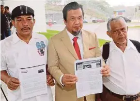  ?? ABD RAHIM RAHMAT
PIC BY ?? Umno Grassroots Movement chairman Datuk Zulkarnain Mahdar (centre) showing a 2011 Malaysiaki­ni report on the alleged embezzleme­nt involving projects in Sabah outside the Malaysian Anti-Corruption Commission’s office in Putrajaya yesterday.