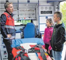  ?? FOTO: SABINE RÖSCH ?? Mario Kling erklärt Hanna und Jonas das Innere eines Rettungsfa­hrzeuges.