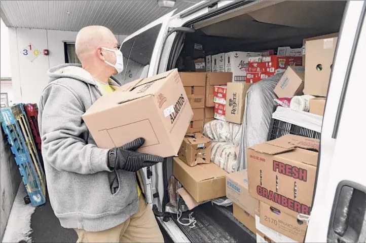  ?? Photos by Lori Van Buren / Times Union ?? Govinda Das of Prabhuji Food Distributi­on loads a van full of food at the Regional Food Bank of Northeaste­rn New York on Thursday in Latham. Das was taking the food to the Catskill area.