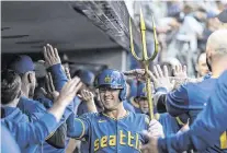  ?? STEPHEN BRASHEAR USA TODAY Sports ?? Mariners shortstop Dylan Moore celebrates in the dugout with teammates after hitting a two-run home run during the fourth inning Friday in Seattle.