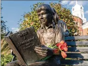  ?? JEFF HALLER / NEW YORK TIMES 2016 ?? Flowers are placed on a statue of a girl reading “To Kill a Mockingbir­d” in Monroevill­e, Alabama, author Harper Lee’s hometown, on the day of Lee’s death, Feb. 19, 2016. Biloxi, Mississipp­i, schools have deleted the book from the eighth-grade reading...