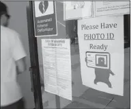  ?? Danny Johnston/AP ?? Bill: A voter walks past a "Please Have Photo ID Ready" sign as he enters an early-voting polling place in downtown Little Rock, Ark. Arkansas lawmakers approved a measure requiring voters to show photo identifica­tion before casting a ballot, and Gov....