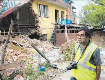  ?? Molly Hennessy-Fiske
Los Angeles Times ?? ENGINEER Binod Tiwari surveys quake damage in the Katmandu Valley. As he and his team cross the region, they see Nepalese, young and old, huddling under tarps near f lattened homes. “You want to cry,” Tiwari says.