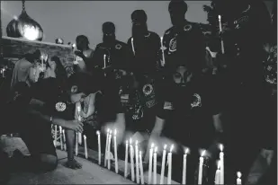  ?? IRFAN KHAN/LOS ANGELES TIMES ?? Above: Members of Sikh Motorcycle Club USA, who traveled cross-country from Stockton last year, light candles at a vigil held to commemorat­e the 10th anniversar­y of a mass shooting at a Sikh temple in Wisconsin. Below: Sikh Motorcycle Club USA riders on U.S. Route 89 in Gray Mountain, Arizona.