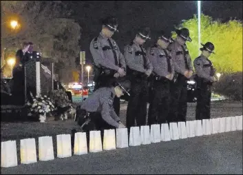  ?? Mike Shoro Las Vegas Review-Journal ?? Nevada Highway Patrol troopers stand during a candleligh­t vigil Friday at the Highway Patrol offices on West Sunset Road.