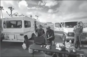  ?? HOWARD LIPIN/SAN DIEGO UNION-TRIBUNE FILE PHOTOGRAPH ?? Residents of the Econoline van, left, prepare a breakfast of donated food on a butane range. Their street names, from left, Noodle, Oak and Noah, in San Diego on March 7.