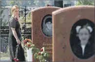  ??  ?? A woman looks at some of the graves of those killed, a year after the Beslan school atrocity of 2004.